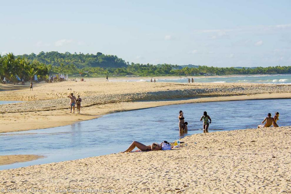 Imagem de turistas nas piscinas naturais da Praia dos Nativos.